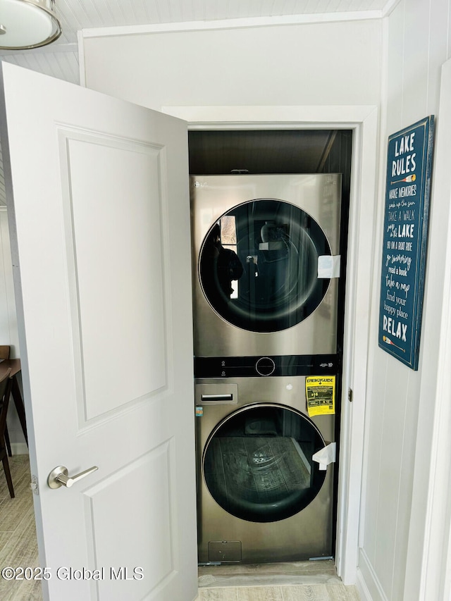 washroom featuring stacked washer and dryer and laundry area