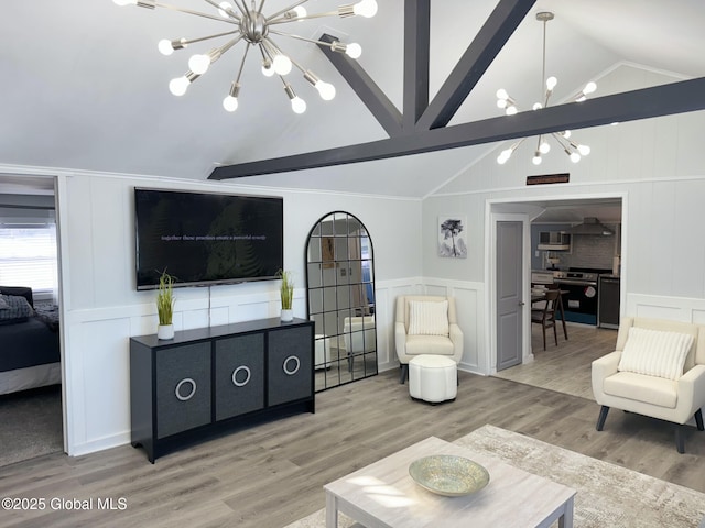 12 Berry Patch Way, Crown Point, NY 12928 - living room featuring a chandelier, a decorative wall, vaulted ceiling, light wood-style floors, and a wainscoted wall