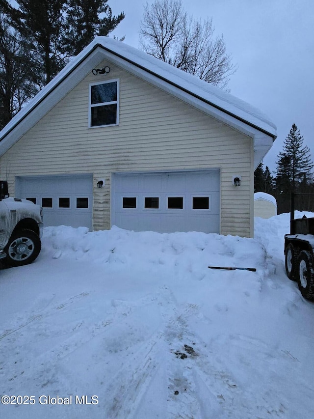 view of snow covered exterior featuring a garage