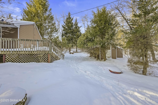 snowy yard featuring a wooden deck