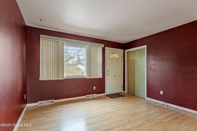 foyer entrance with visible vents, light wood-type flooring, and baseboards