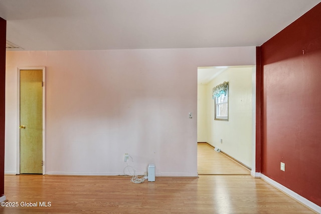 empty room featuring light wood-style floors and baseboards