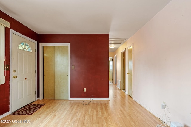 foyer entrance featuring visible vents, baseboards, and wood finished floors