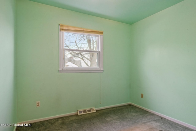 spare room featuring carpet flooring, baseboards, and visible vents