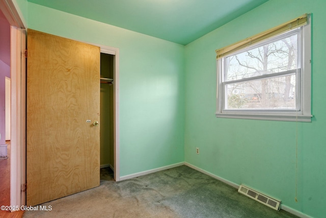 unfurnished bedroom with carpet flooring, baseboards, visible vents, and a closet