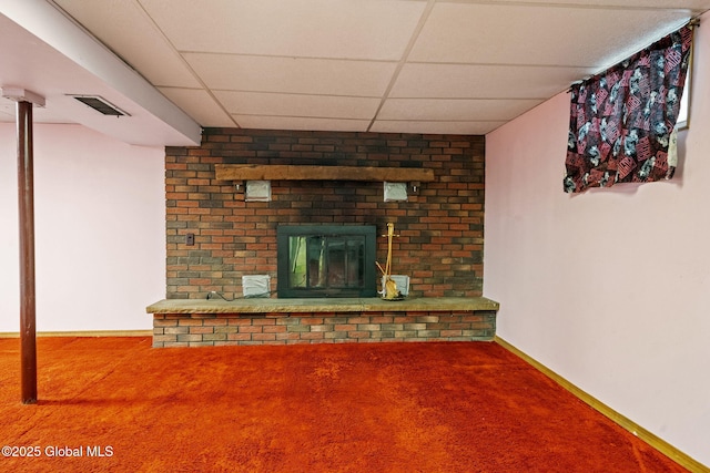 unfurnished living room with visible vents, baseboards, carpet floors, a paneled ceiling, and a brick fireplace