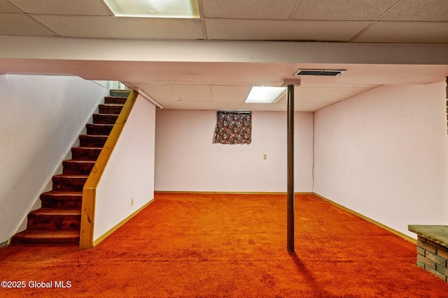 finished basement featuring stairs, carpet, visible vents, and a drop ceiling