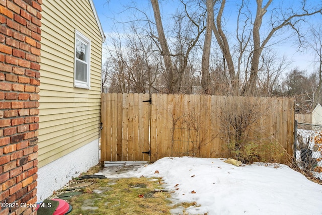 yard covered in snow featuring fence