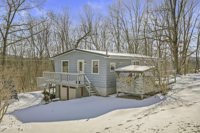 snow covered rear of property featuring a wooden deck