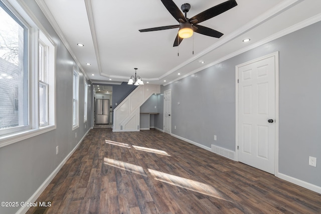 unfurnished living room with ornamental molding, dark wood-type flooring, a raised ceiling, and baseboards