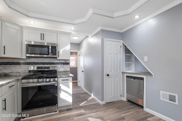 kitchen with light wood-style floors, visible vents, appliances with stainless steel finishes, and a tray ceiling