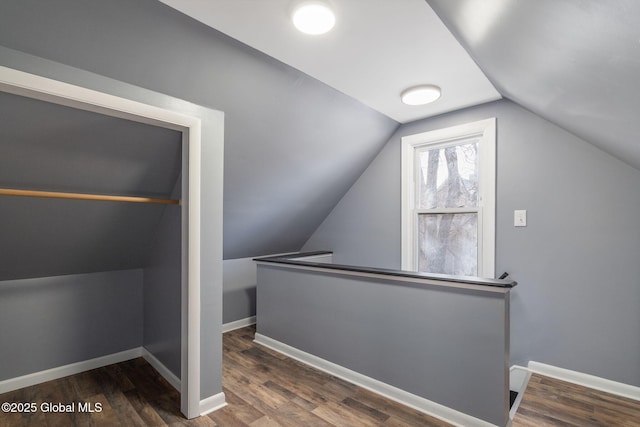 additional living space with vaulted ceiling, wood finished floors, and baseboards