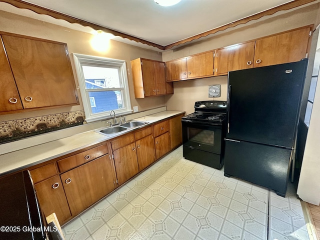 kitchen featuring black appliances, brown cabinetry, light countertops, and a sink