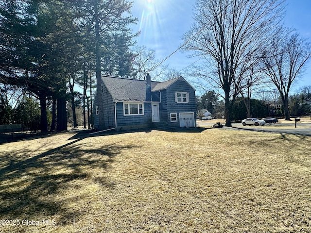 view of property exterior featuring an attached garage and a chimney