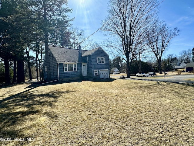 view of property exterior with a garage and a chimney