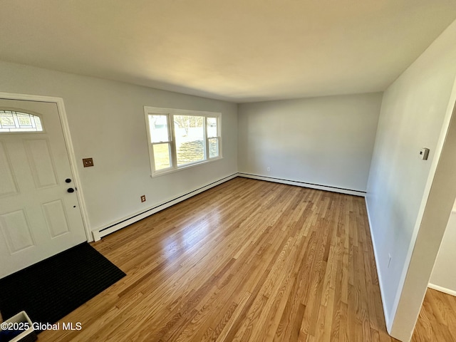 foyer entrance featuring baseboards, light wood-style floors, and baseboard heating