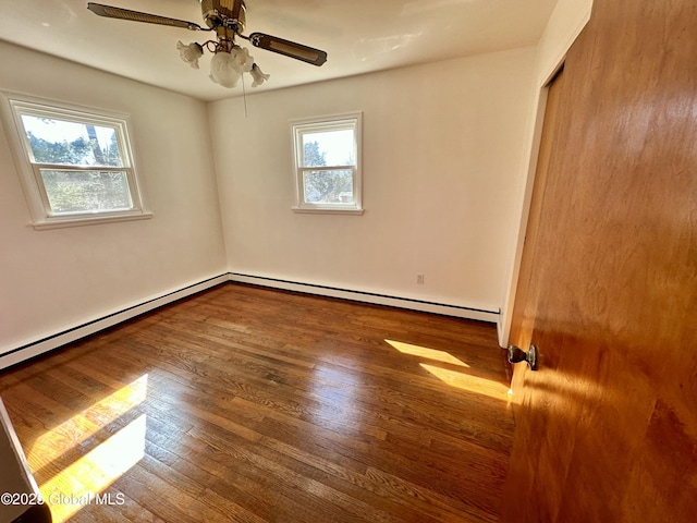 empty room with ceiling fan, baseboard heating, a healthy amount of sunlight, and wood finished floors