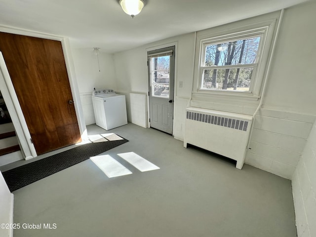 laundry room with a wainscoted wall, washer / clothes dryer, radiator heating unit, and laundry area