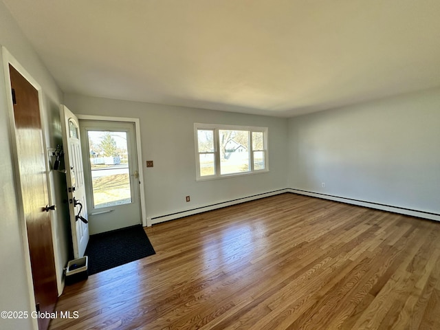 foyer with a healthy amount of sunlight, wood finished floors, and a baseboard radiator