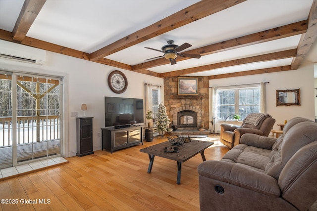 76 Barney Rd, Greenfield, NY 12850 - living room with a wall mounted AC, light wood finished floors, a ceiling fan, a stone fireplace, and beam ceiling