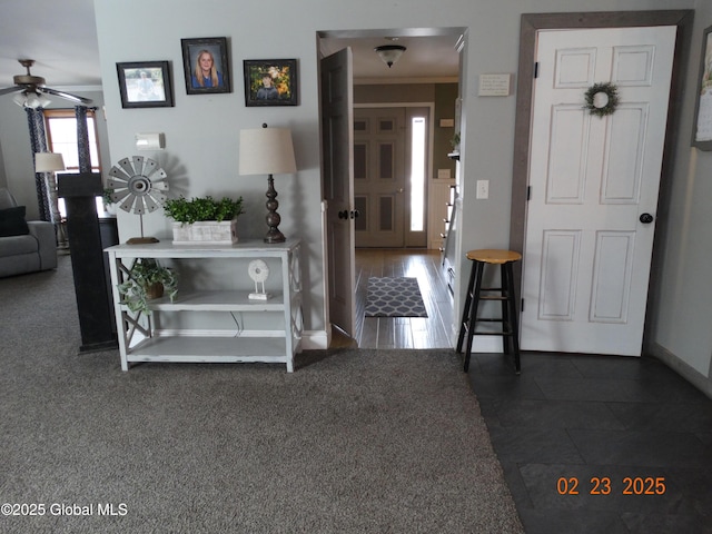 foyer entrance featuring ceiling fan and baseboards