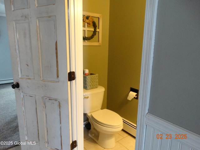 bathroom featuring a baseboard heating unit, tile patterned flooring, and toilet