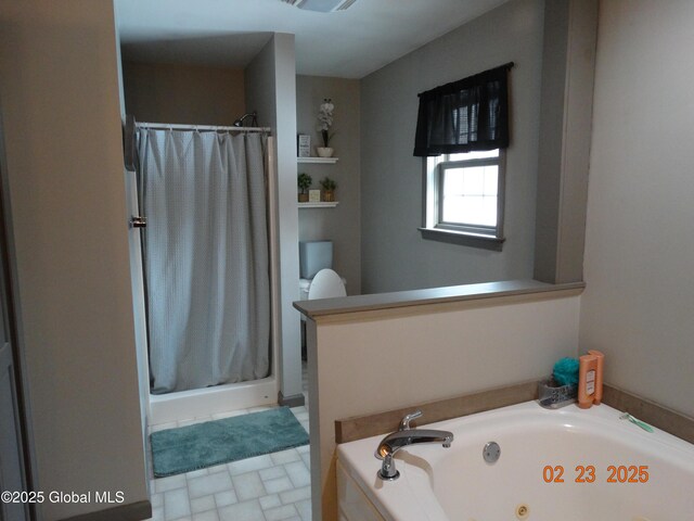 bathroom with a stall shower and a jetted tub