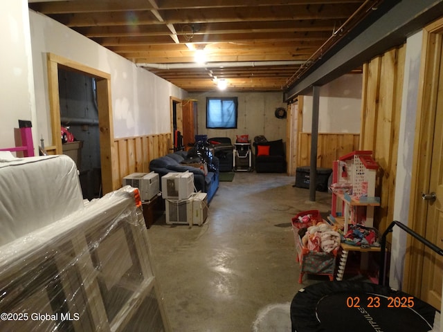 unfinished basement with a wainscoted wall and wooden walls