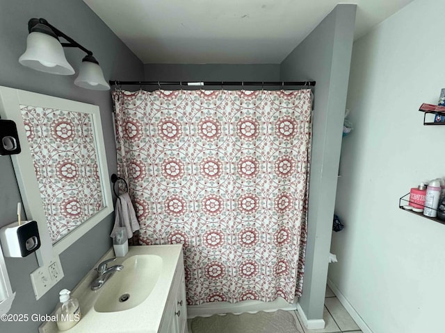 full bath featuring a shower with curtain, tile patterned floors, baseboards, and vanity