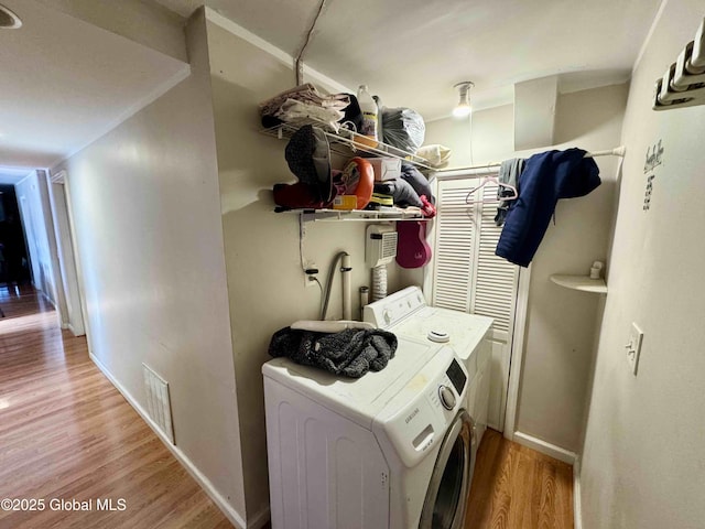 laundry room with washer / clothes dryer, visible vents, light wood-style floors, laundry area, and baseboards