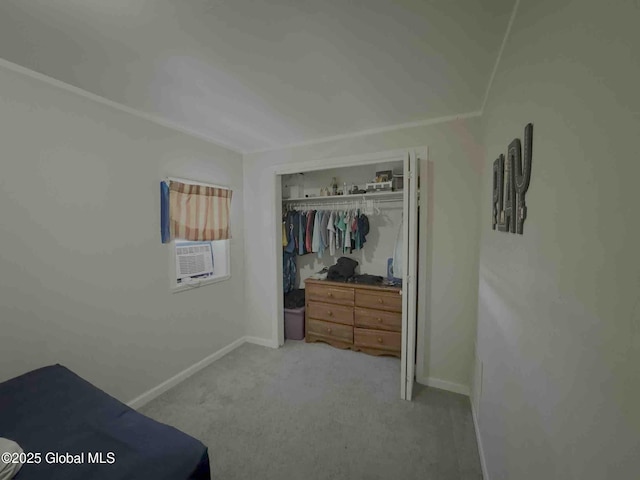 bedroom with cooling unit, baseboards, a closet, and light colored carpet