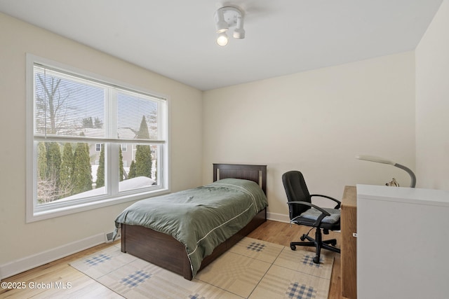 bedroom with light wood-style flooring and baseboards