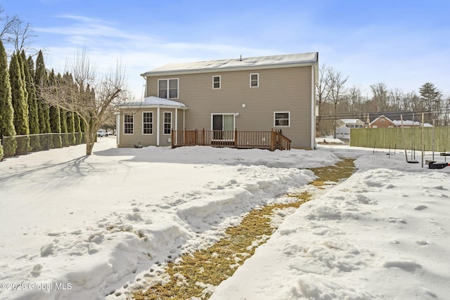 snow covered property featuring fence and a wooden deck