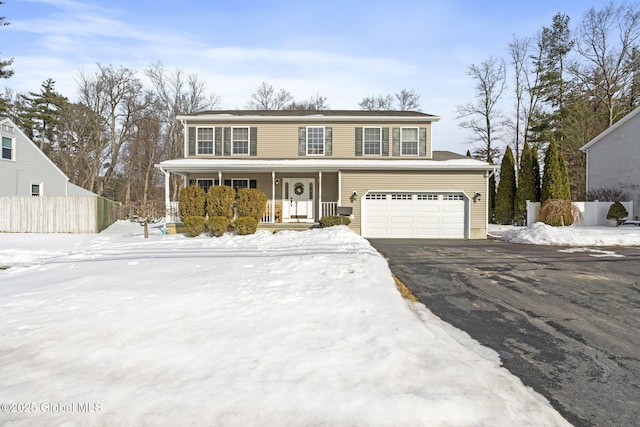 view of front of property featuring an attached garage, a porch, fence, and aphalt driveway