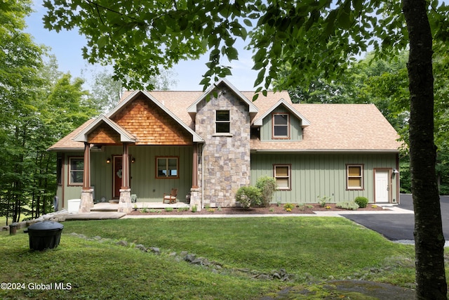 view of front of home featuring a front lawn, board and batten siding, and roof with shingles