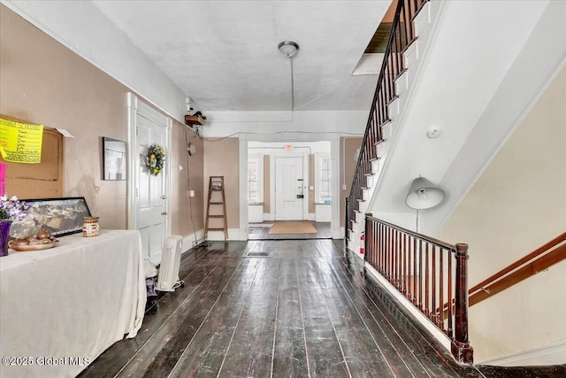 entryway featuring dark wood-style floors, stairway, and baseboards