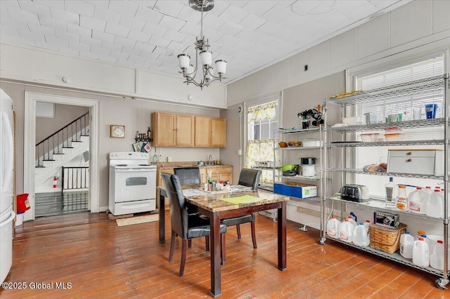 dining area featuring a chandelier, stairs, ornamental molding, and wood finished floors