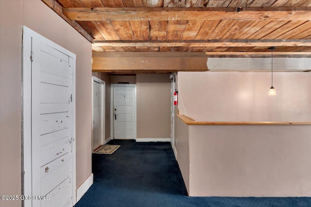 basement featuring dark colored carpet, wooden ceiling, and baseboards