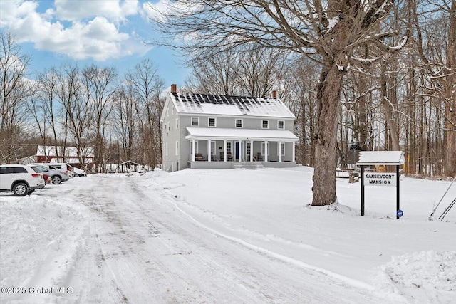 view of front of property featuring covered porch and a chimney