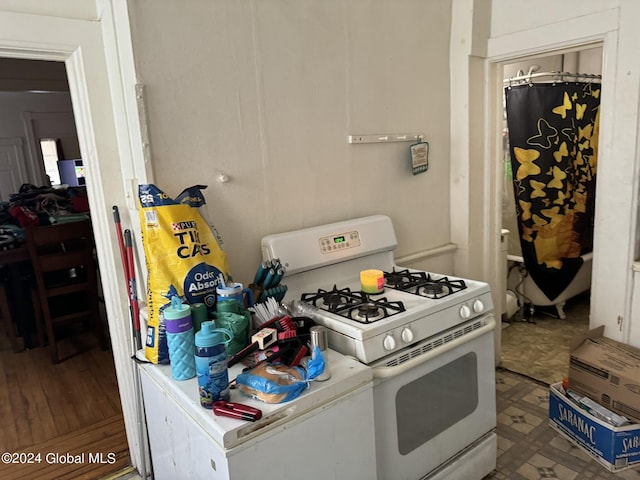 kitchen with tile patterned floors, light countertops, and white gas range oven