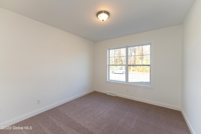 carpeted empty room with visible vents and baseboards