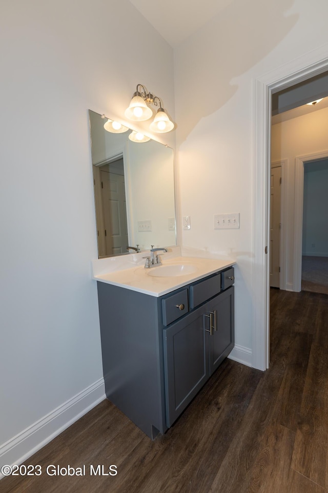 bathroom with vanity, baseboards, and wood finished floors