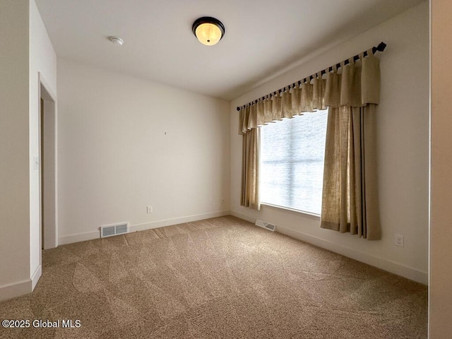 carpeted empty room featuring visible vents and baseboards