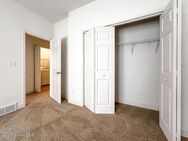 unfurnished bedroom featuring a closet, carpet, washer / clothes dryer, and visible vents