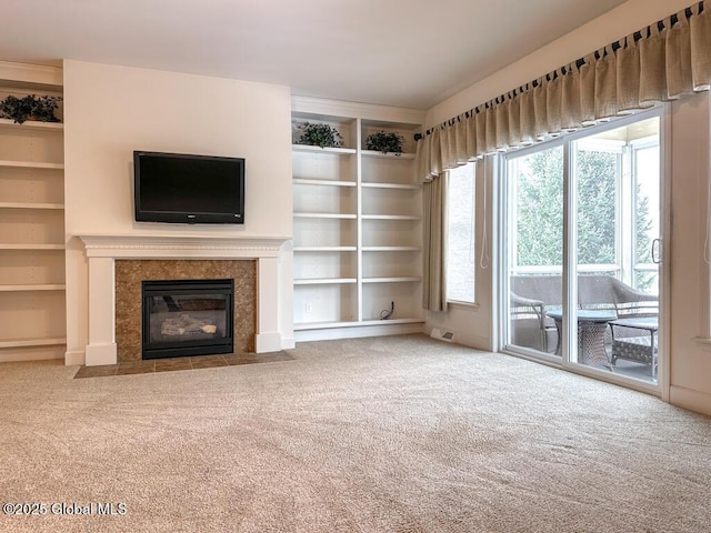 unfurnished living room featuring carpet floors, a premium fireplace, and built in features