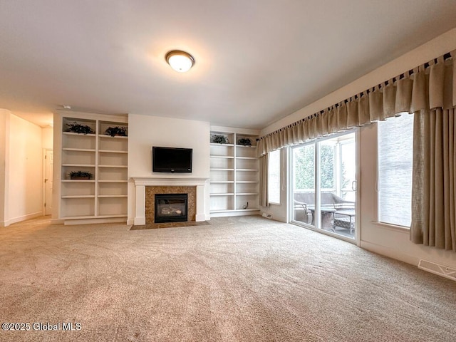 unfurnished living room featuring a fireplace with flush hearth, carpet floors, and baseboards