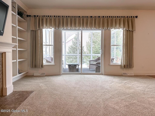 carpeted spare room featuring visible vents