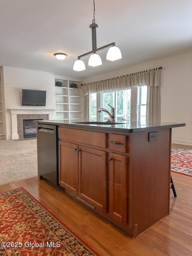 kitchen with pendant lighting, a center island with sink, brown cabinetry, open floor plan, and dishwasher