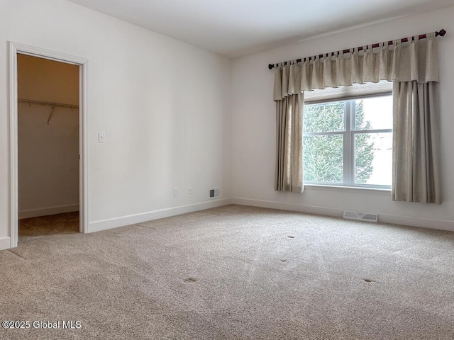 carpeted empty room featuring visible vents and baseboards