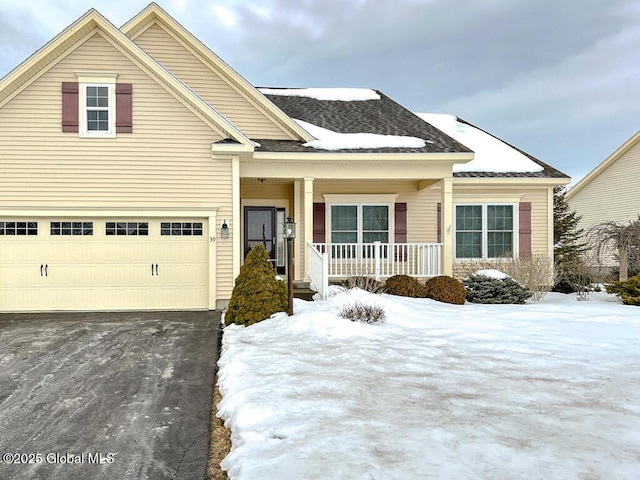 view of front of property with aphalt driveway, covered porch, and a garage